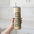Gold glitter skinny tumbler with straw, black motivational quote on front, held in hand