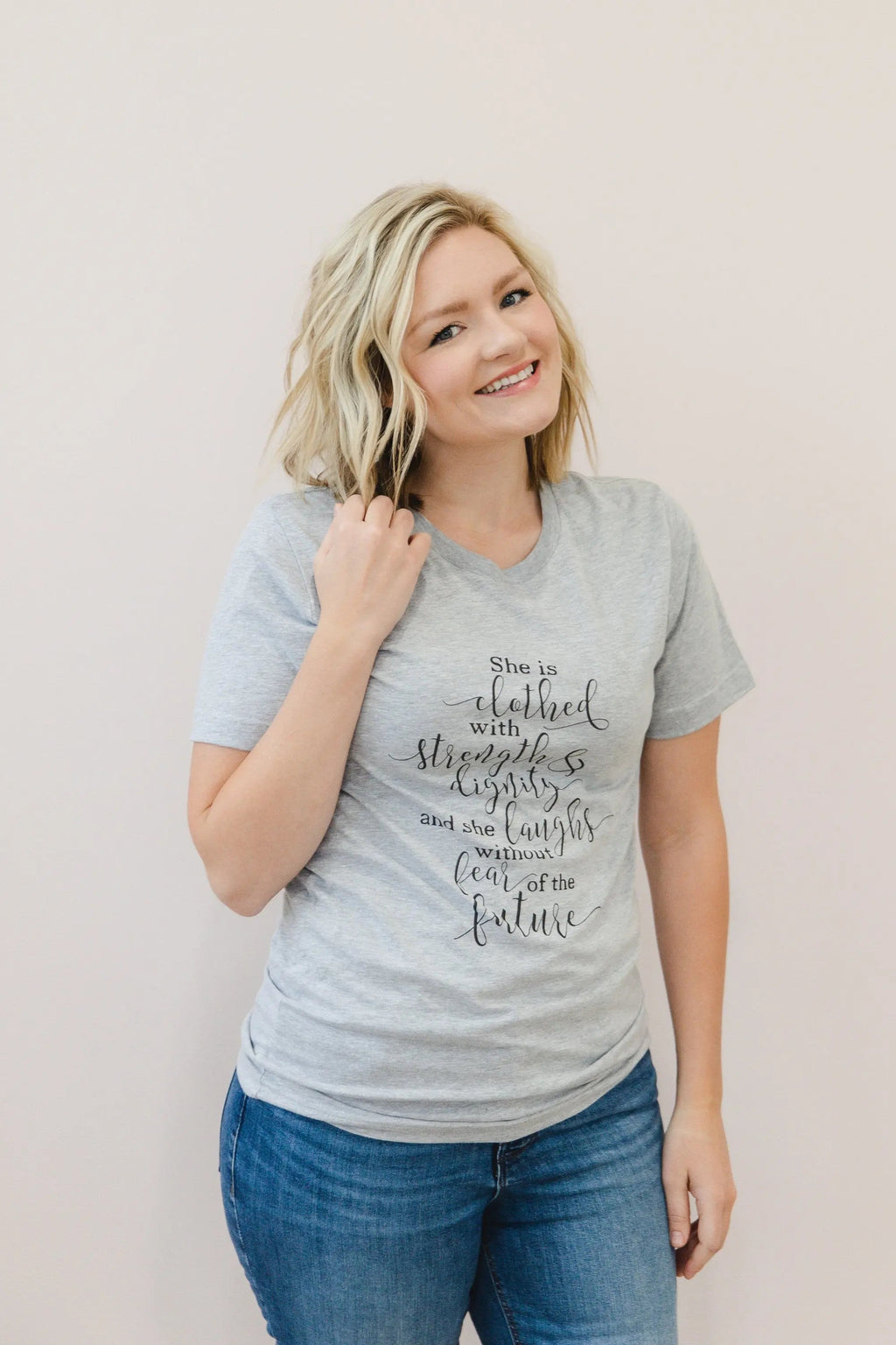 Heather gray women's graphic T-shirt with "She is clothed..." verse on front.