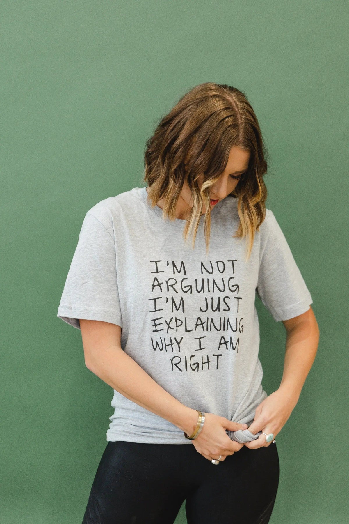 Model wearing heather gray unisex T-shirt with front quote text: “I’m not arguing…”
