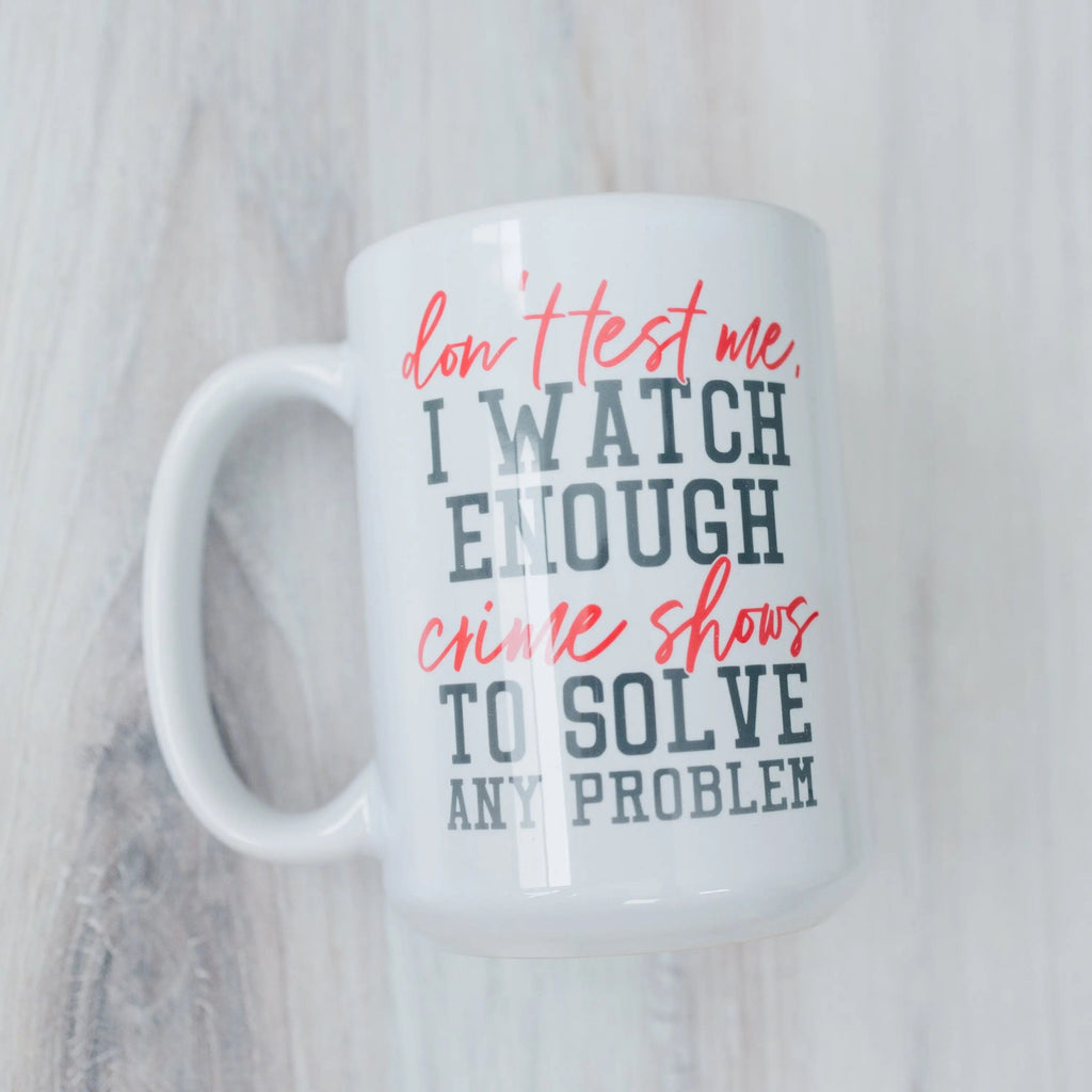 White mug with red and blue 'don't test me' crime shows quote: solve any problem