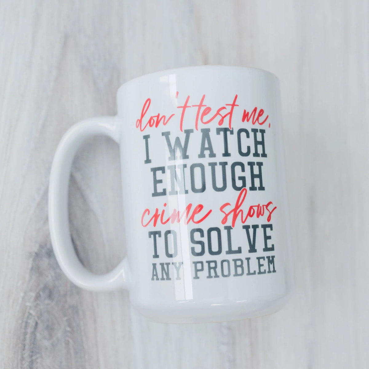 White mug with red and blue 'don't test me' crime shows quote: solve any problem