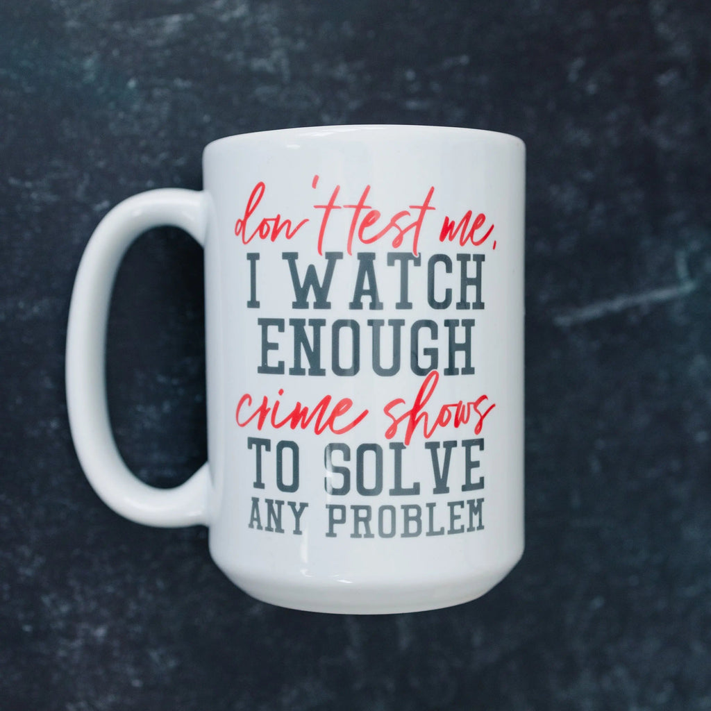 White coffee mug with 'I WATCH ENOUGH' crime shows quote in red and blue