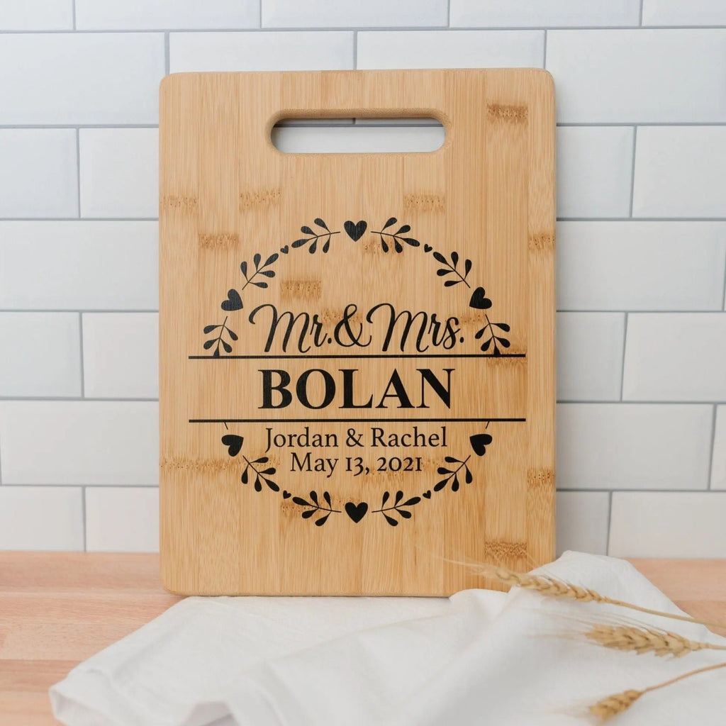 Light wood cutting board with handle slot and engraved 'Mr & Mrs BOLAN' design