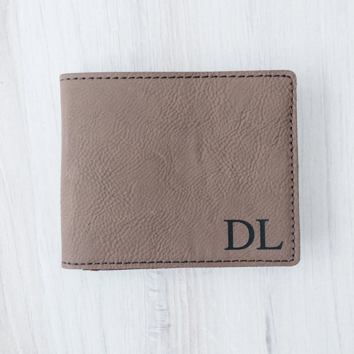 Light brown leather wallet with monogram DL and stitched edges