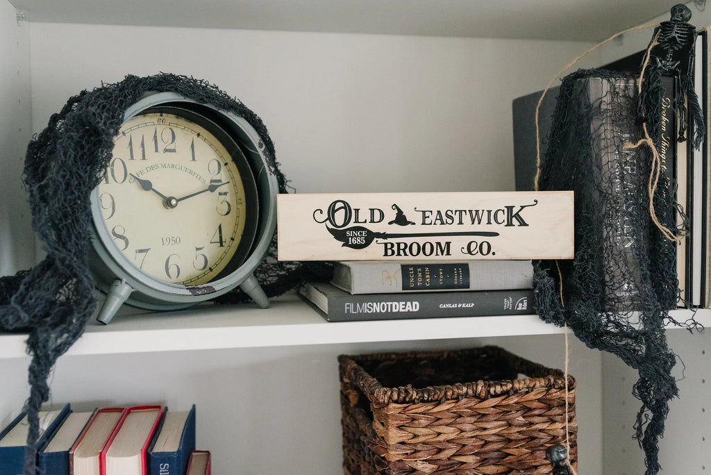 Cream wood shelf sign with Old Eastwick Broom Co. lettering