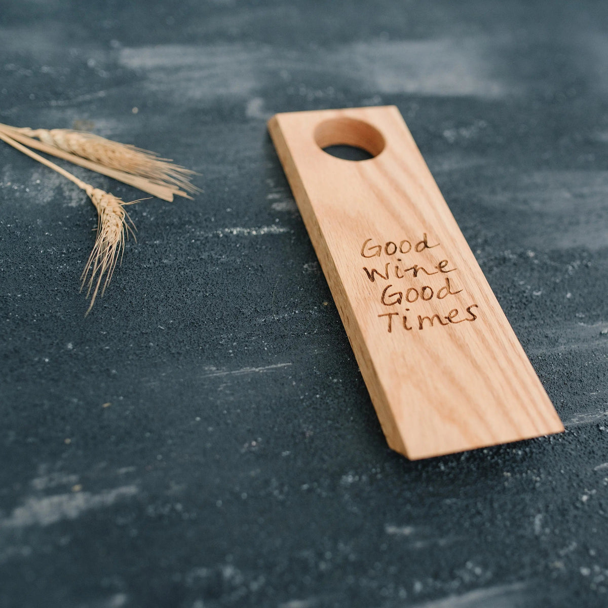 Wood wine bottle holder with round hole and 'Good Wine Good Times' engraving, angled