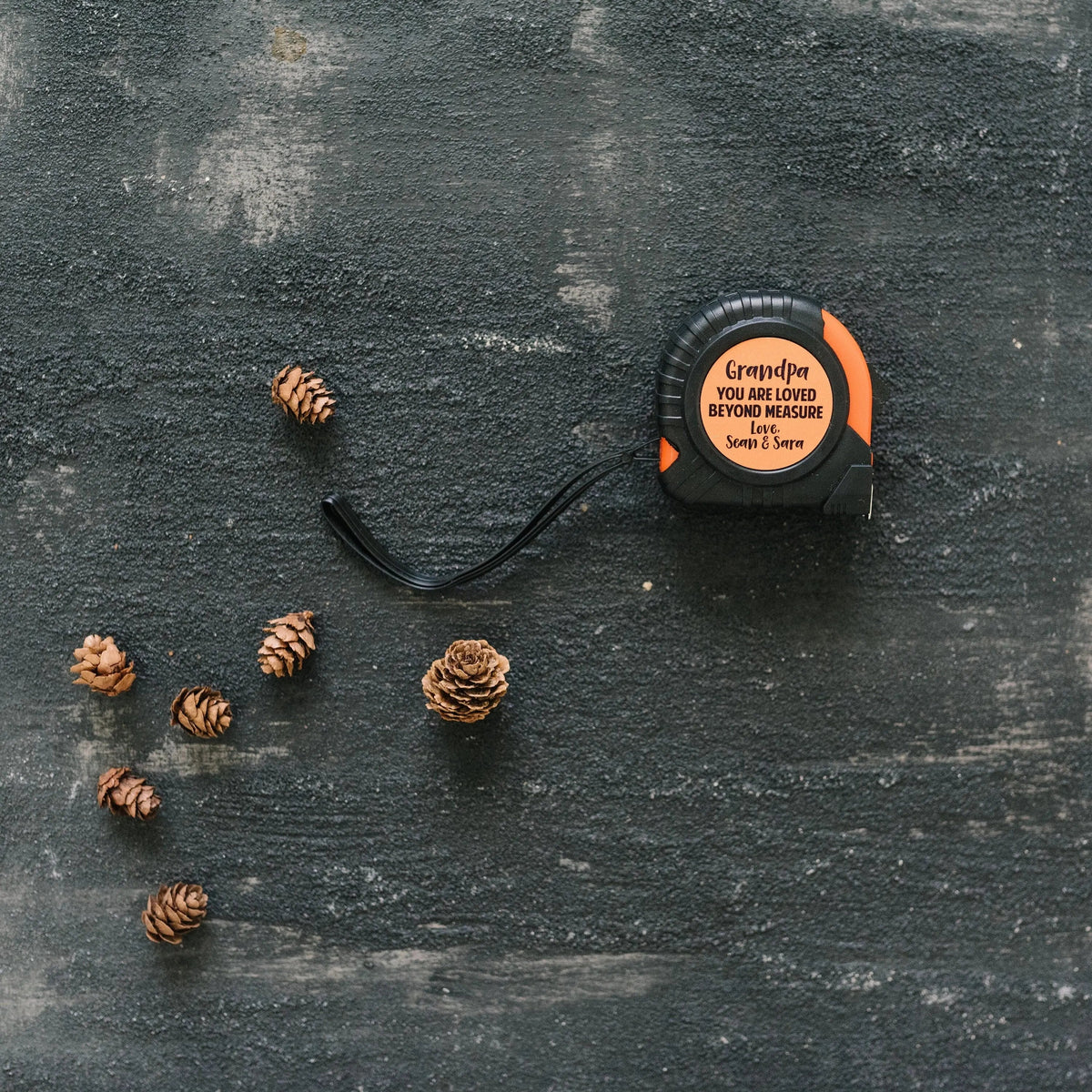Personalized tape measure with custom 'Grandpa' text on orange circular label