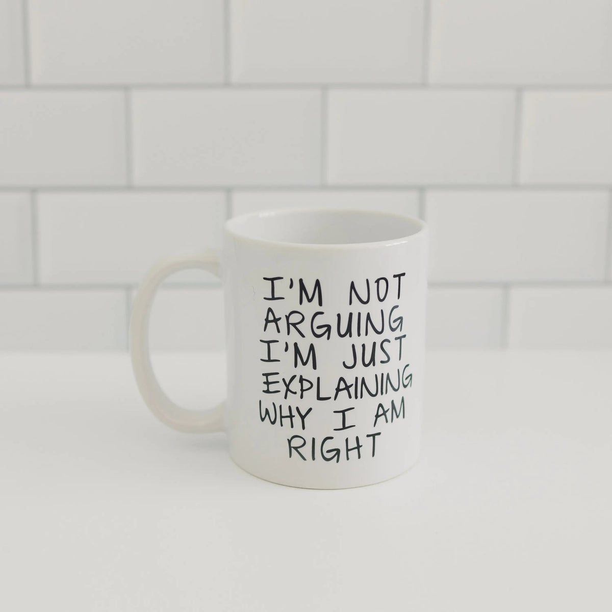 White ceramic coffee mug with black quote text on front, centered
