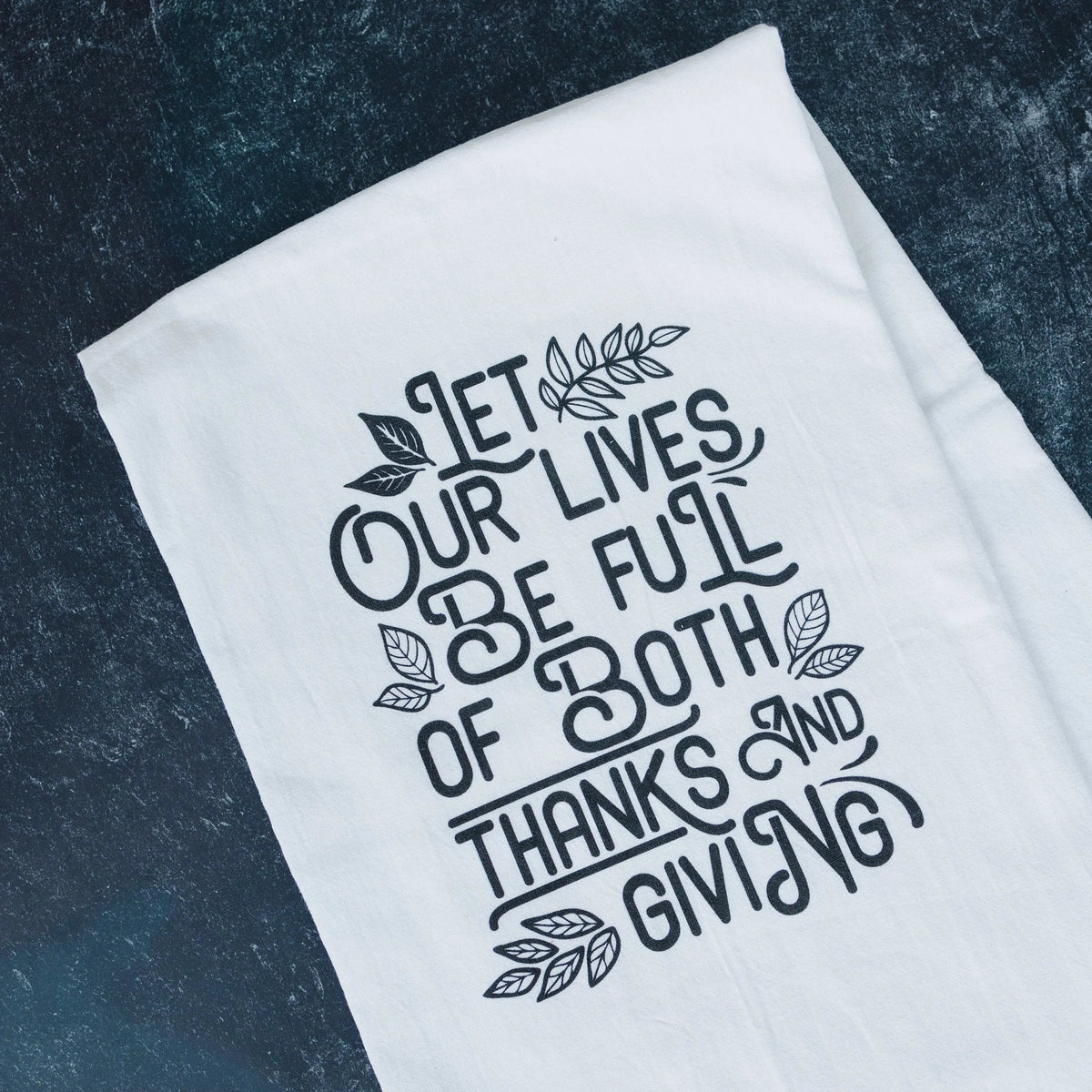 Angled Thanksgiving kitchen towel, white with black quote and leaf details