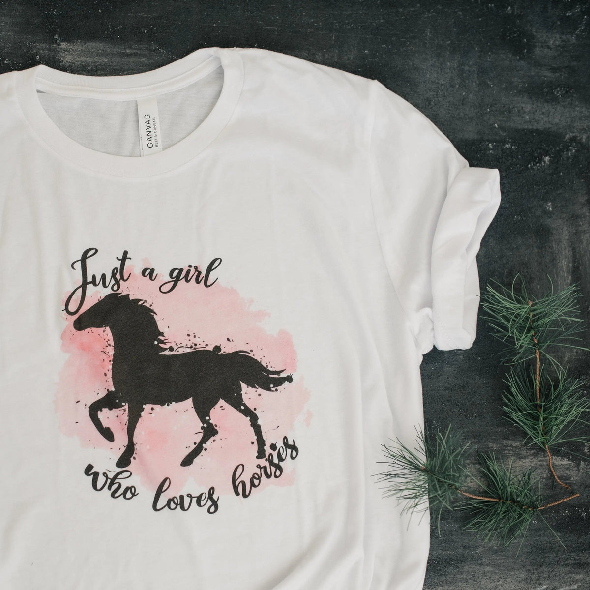 White short-sleeve T-shirt with black horse graphic and pink watercolor splash