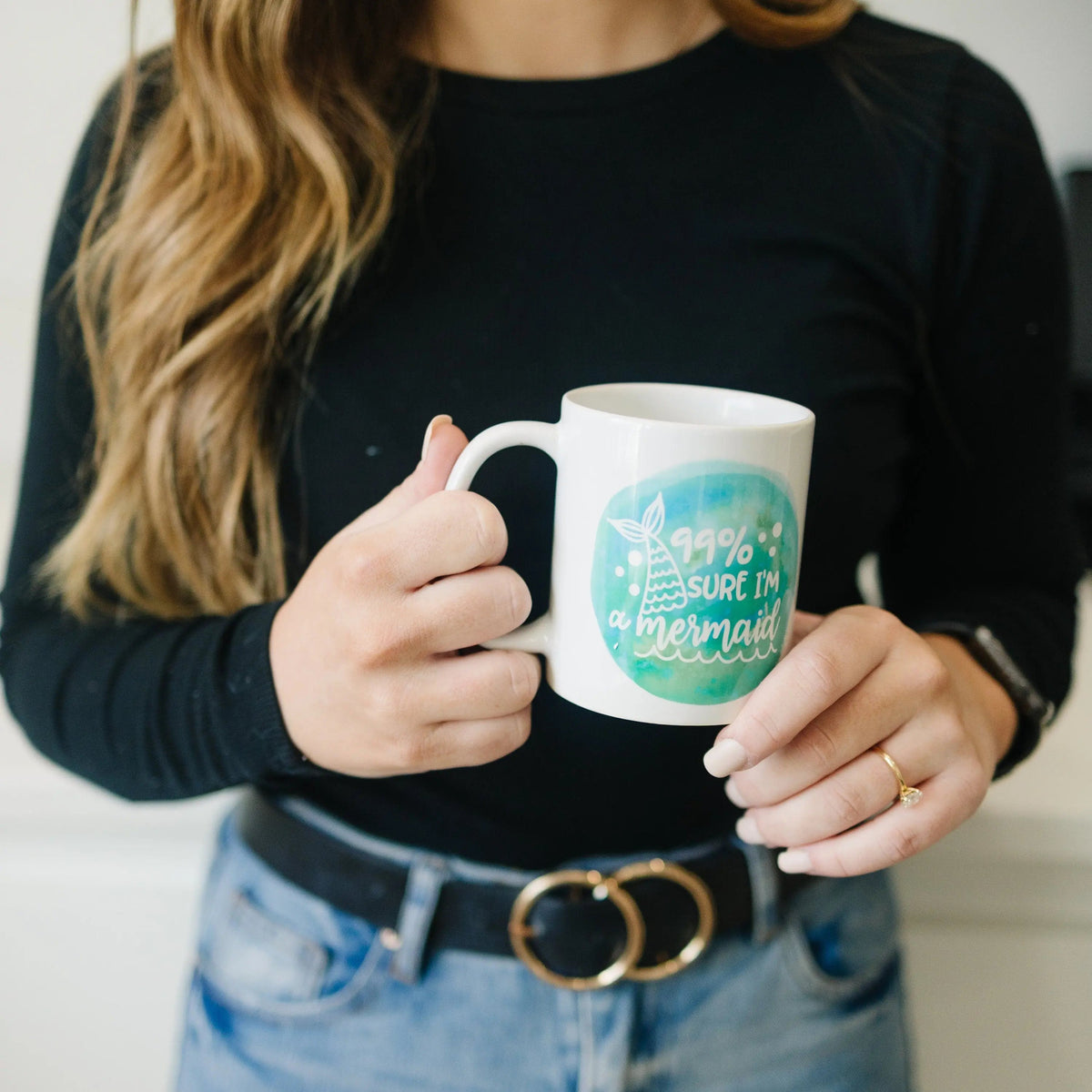 White mug showing teal watercolor mermaid graphic that says '99% sure I'm a mermaid'