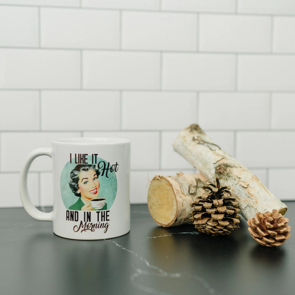 White coffee mug front view with 'I like it hot and in the morning' quote and face graphic