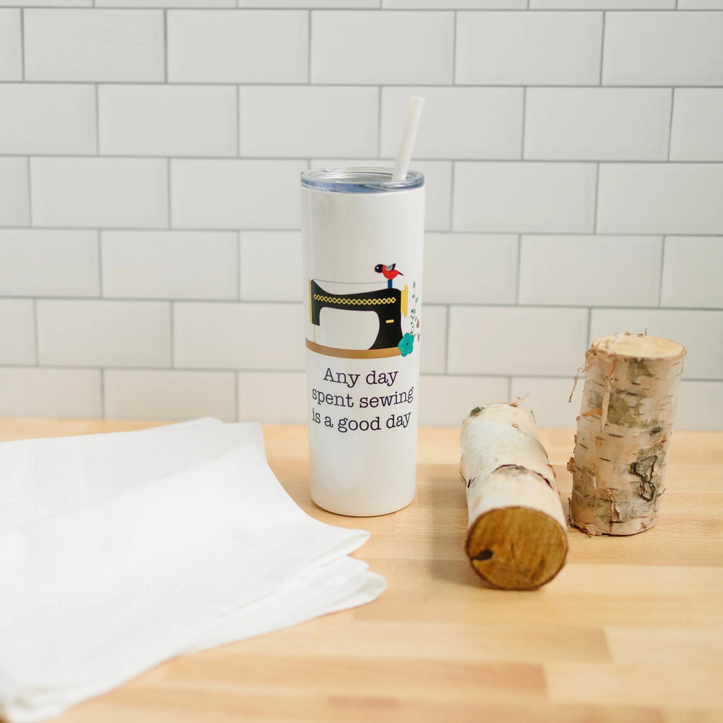 White skinny travel tumbler with straw and sewing machine decal with small quote