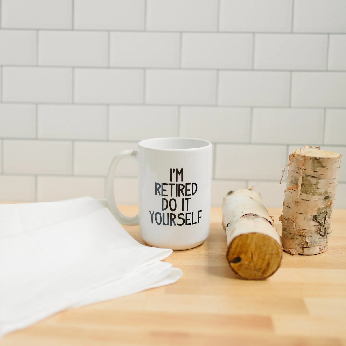 White ceramic retirement coffee mug with "I'm retired do it yourself" text and handle