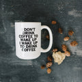 White ceramic coffee mug with "I don't drink coffee..." quote in bold black text