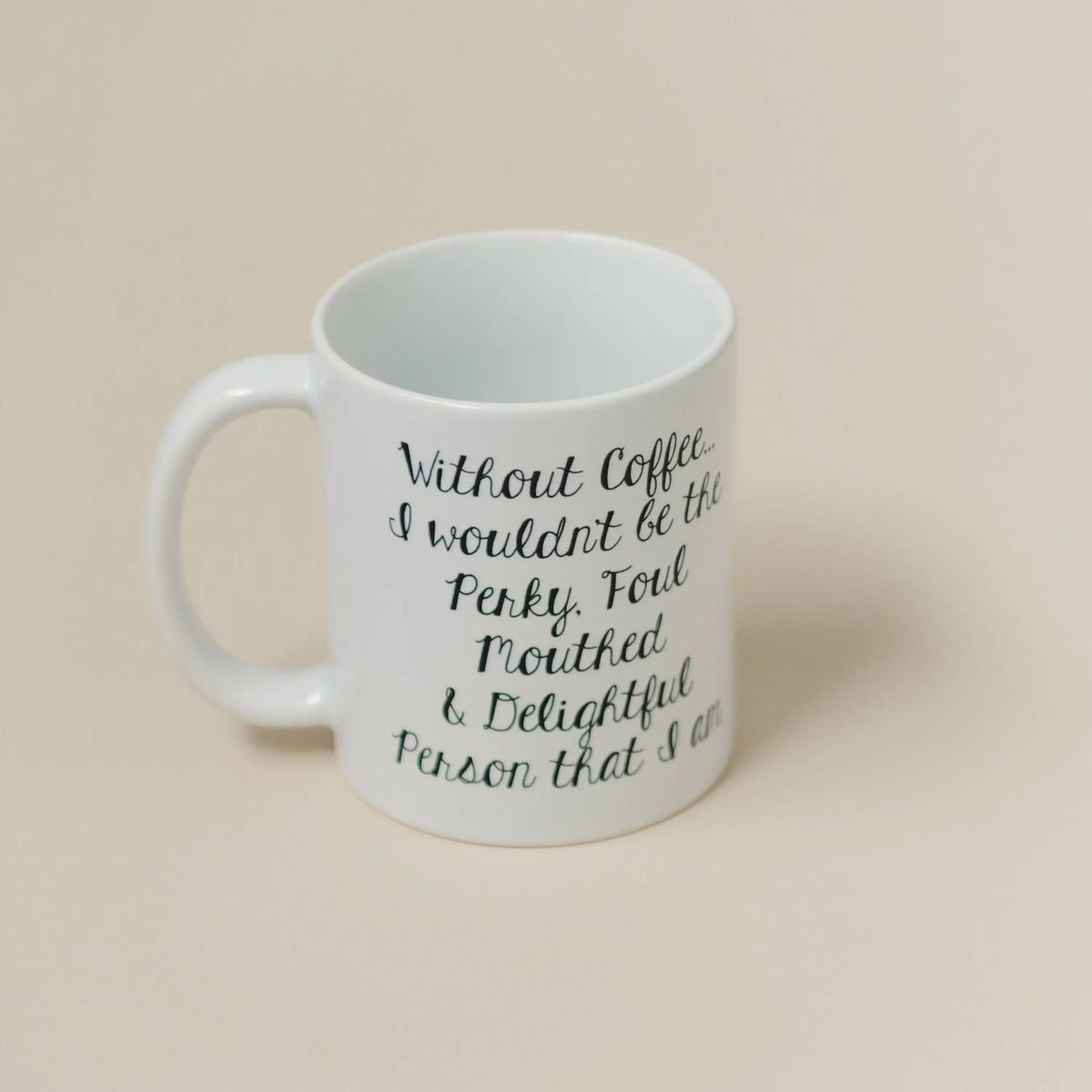 White ceramic coffee mug with black cursive quote, front view