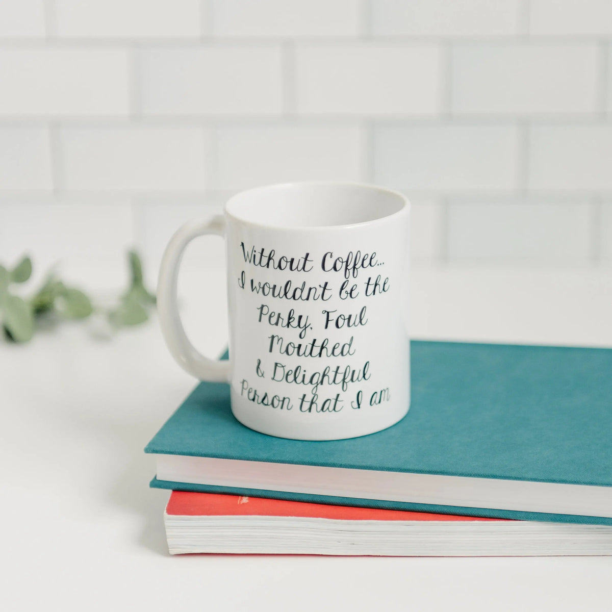 White ceramic mug with teal-blue cursive quote on the front