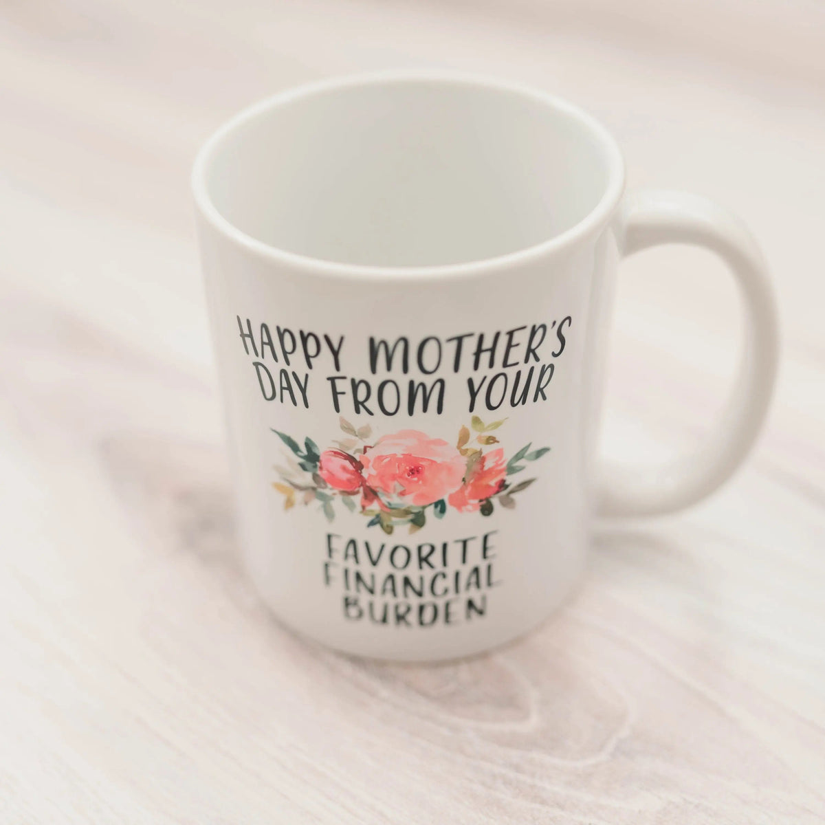 White ceramic coffee mug with floral “Happy Mother’s Day” and “Favorite Financial Burden”