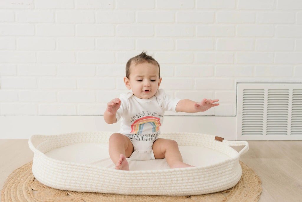 Baby wearing white rainbow “Sunshine” bodysuit with snap bottom, short sleeves