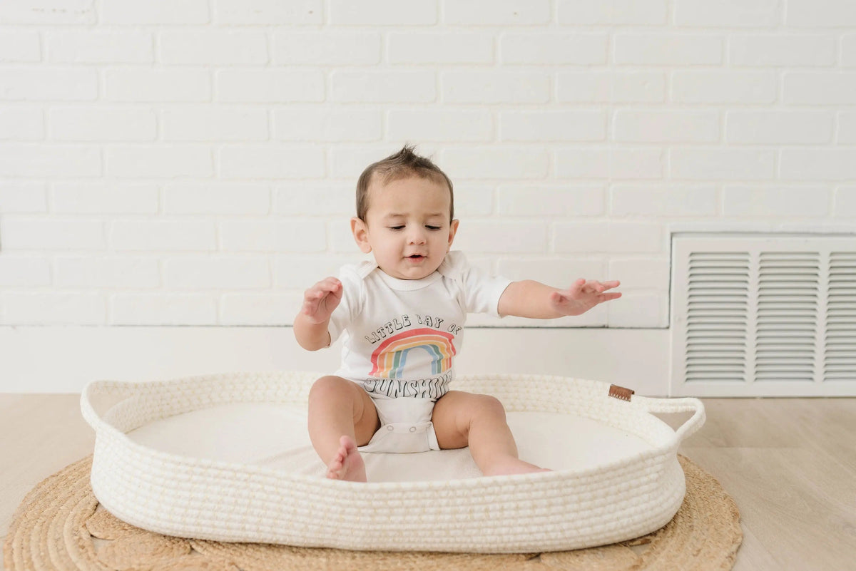 Baby wearing white rainbow “Sunshine” bodysuit with snap bottom, short sleeves