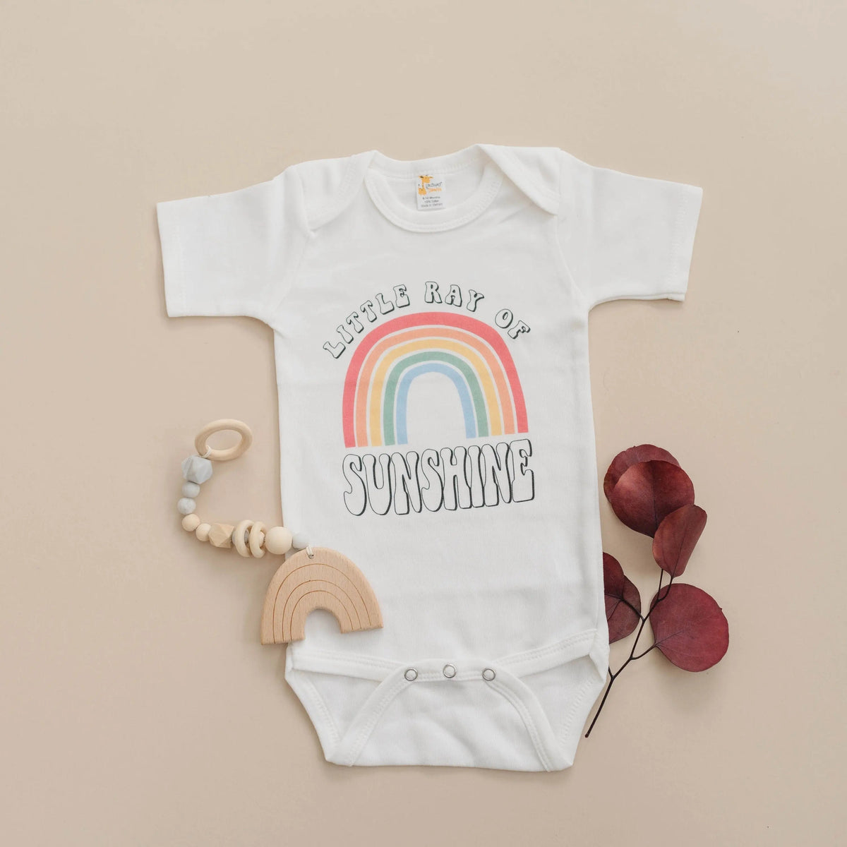 White baby bodysuit with rainbow “Sunshine” graphic, short sleeves, snap bottom
