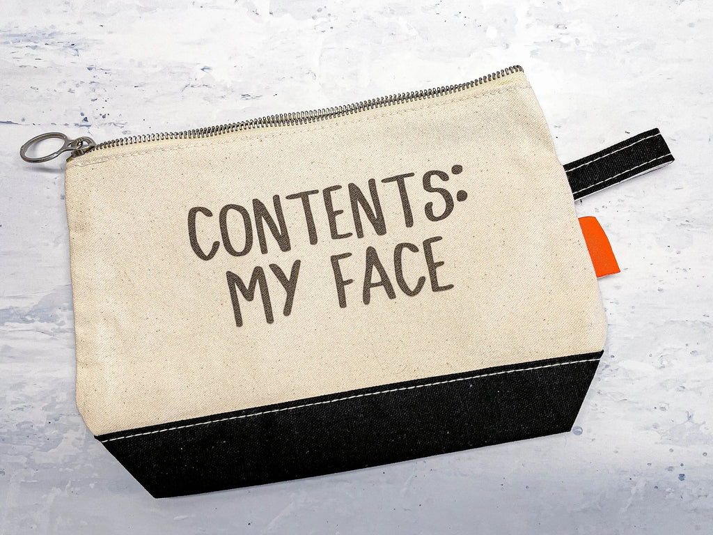 Beige canvas zip cosmetic bag with black bottom, metal zipper pull, text CONTENTS: MY FACE