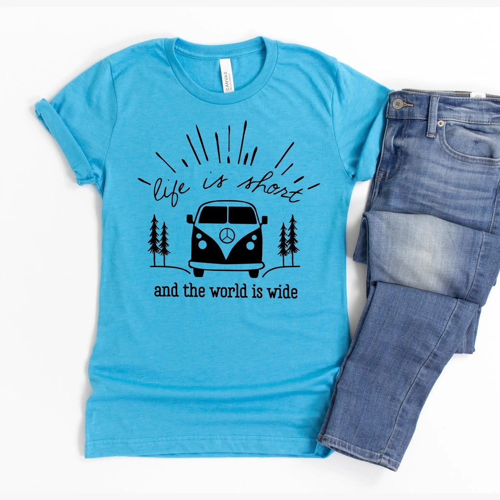 Turquoise graphic t-shirt with camper van and trees graphic, paired with blue jeans