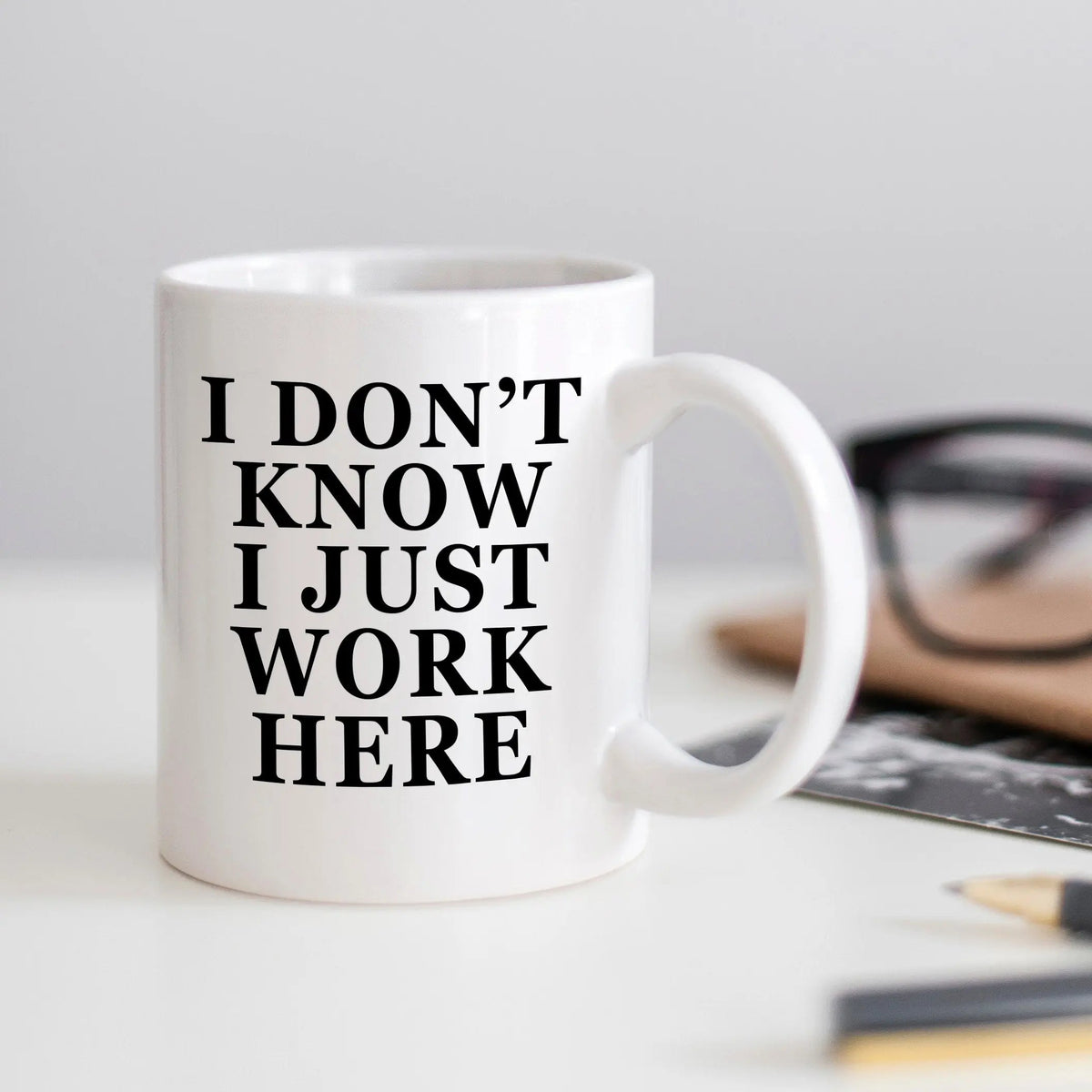 White ceramic coffee mug with text: I DON'T KNOW I JUST WORK HERE