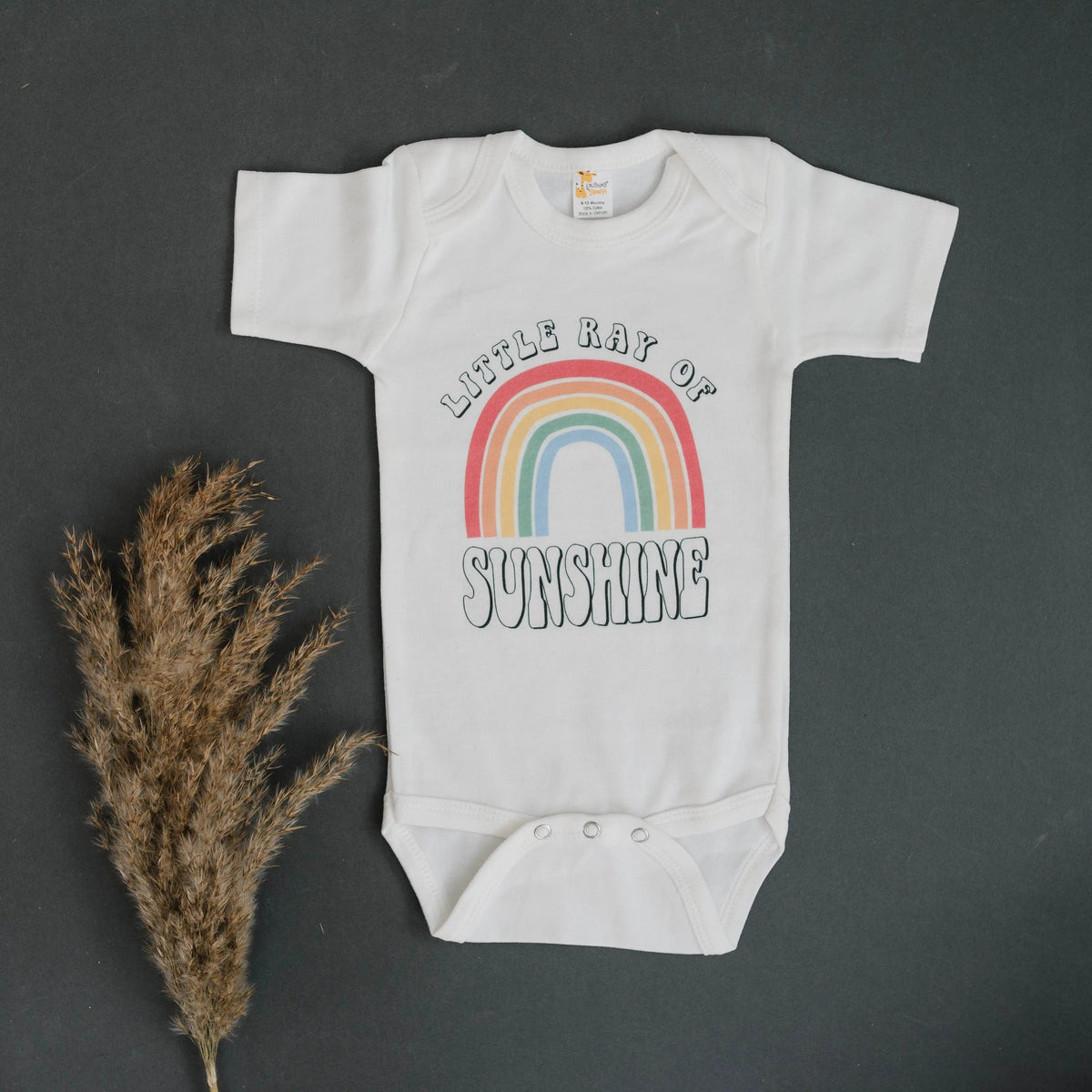 White baby bodysuit with rainbow “Sunshine” graphic, snap bottom, short sleeves