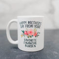 White ceramic coffee mug with floral “Happy Mother’s Day” and “Favorite Financial Burden” text