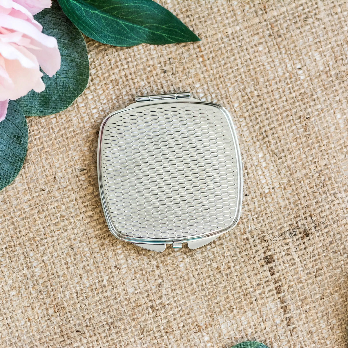 Square compact mirror with silver frame and white textured back surface