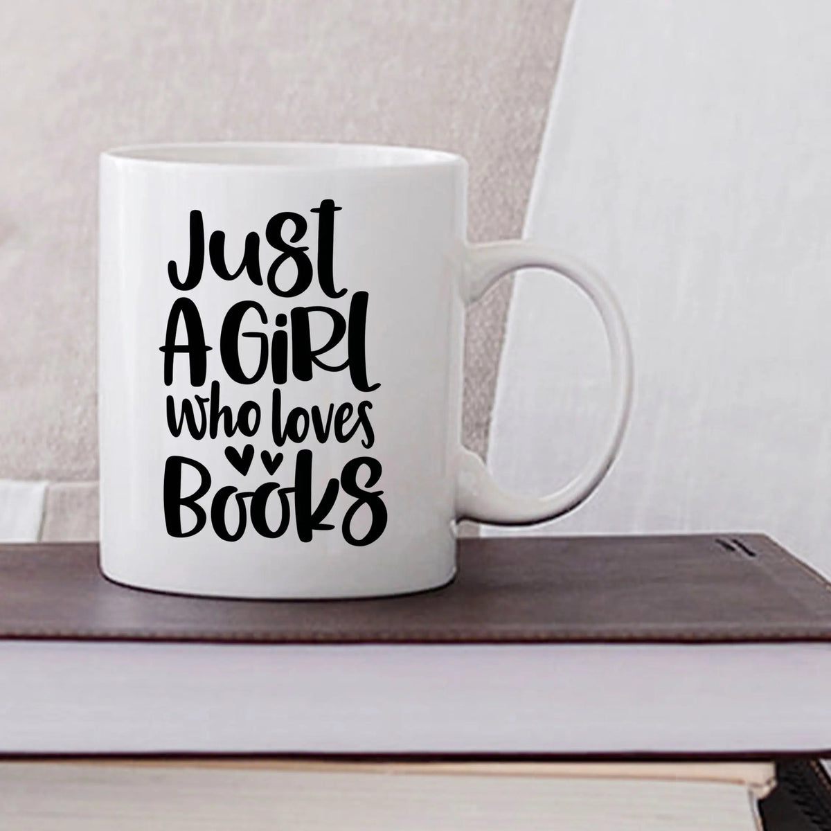 White ceramic coffee mug with black "Just a Girl who loves Books" text