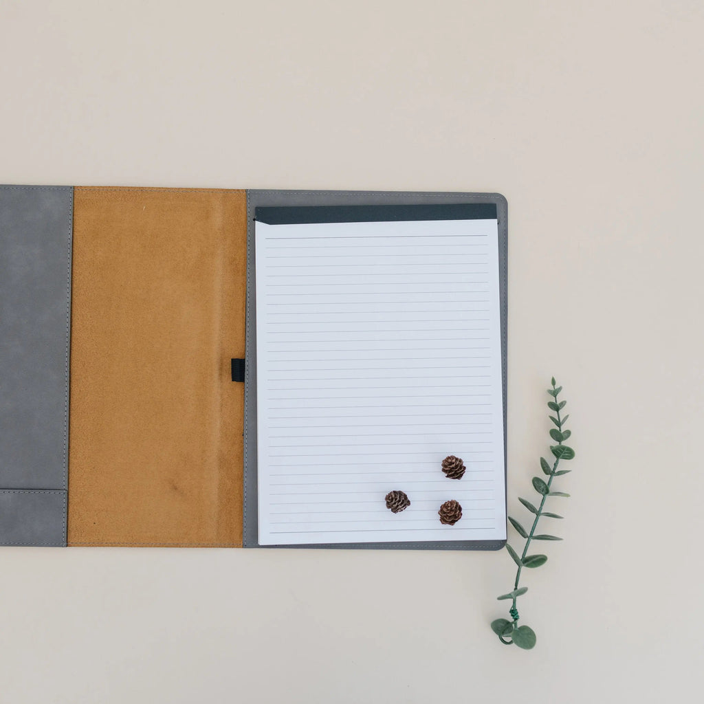 Legal pad portfolio open to lined paper with tan interior panels and stitched edges
