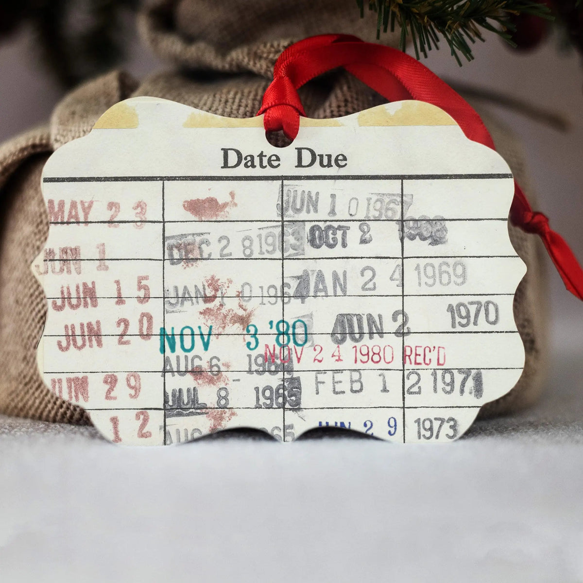 Date Due Christmas ornament with red ribbon and vintage calendar date text