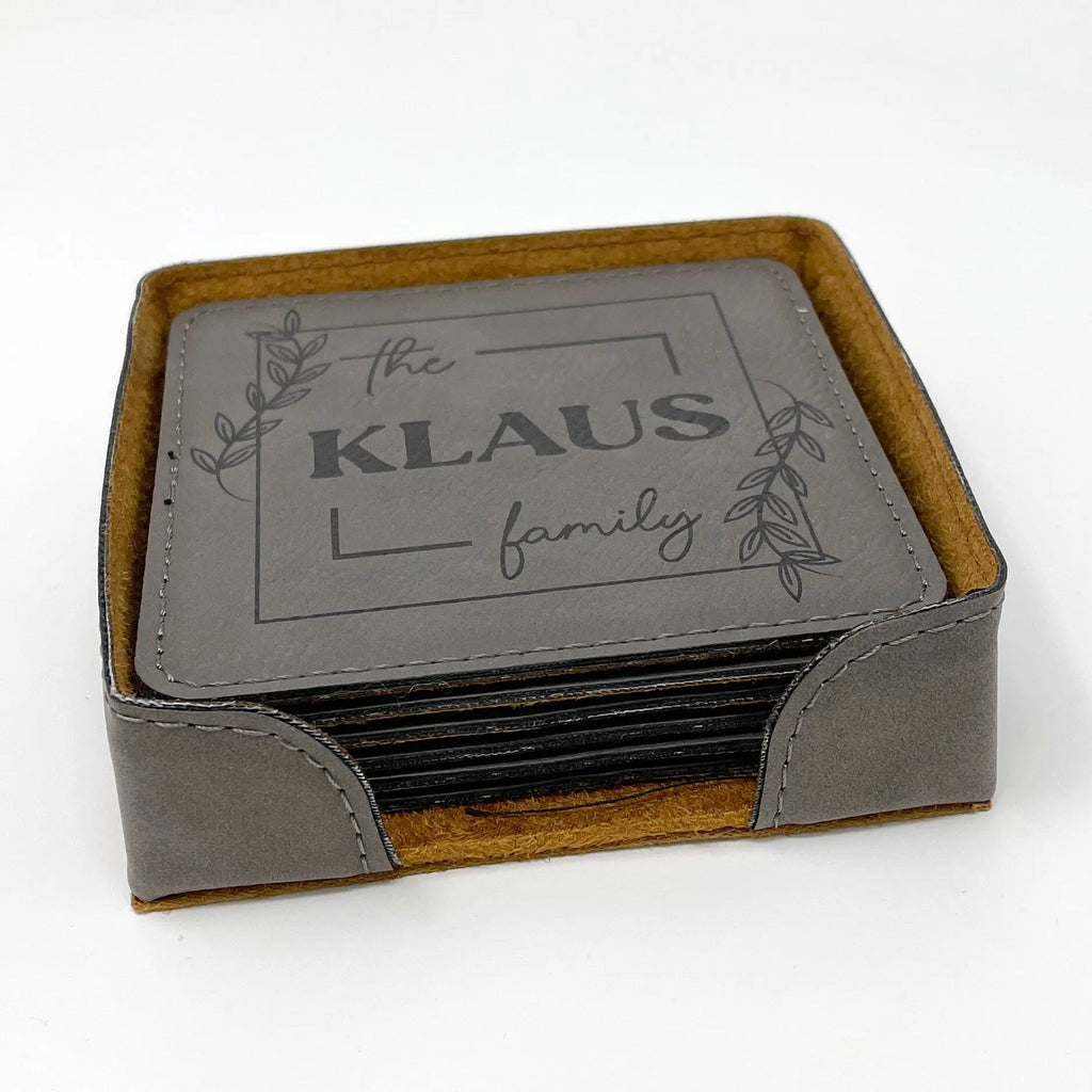 Personalized coaster set in holder, stacked gray coasters with "the KLAUS family" design