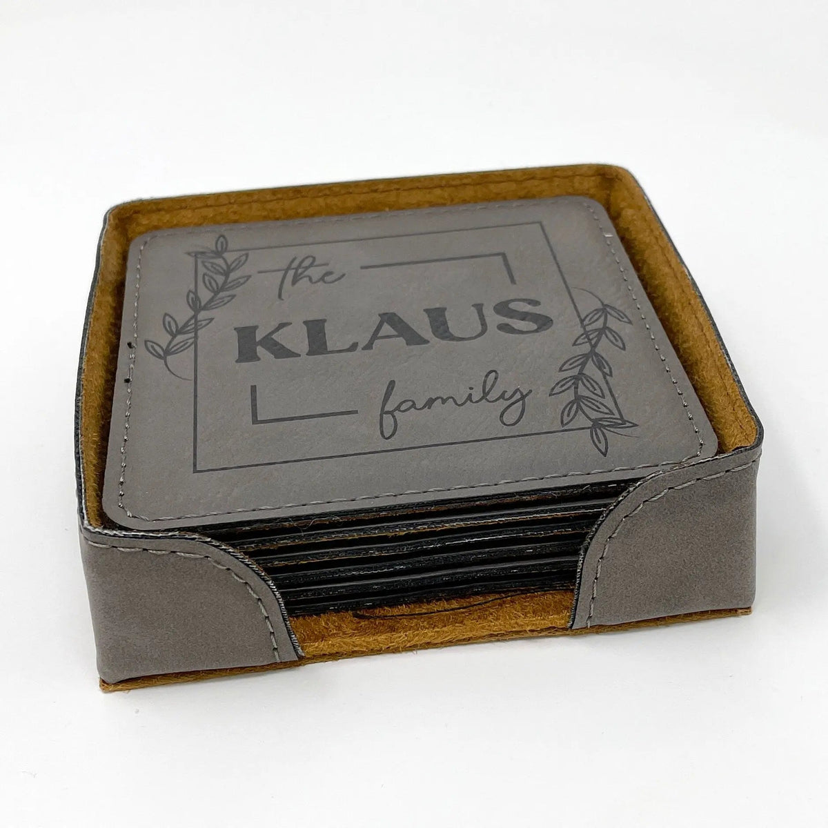 Personalized coaster set in holder, stacked gray coasters with "the KLAUS family" design