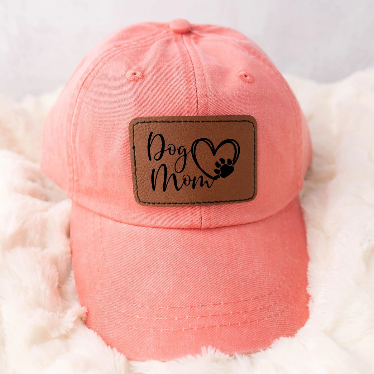Coral baseball cap with leather-look patch reading 'Dog Mom' with paw print