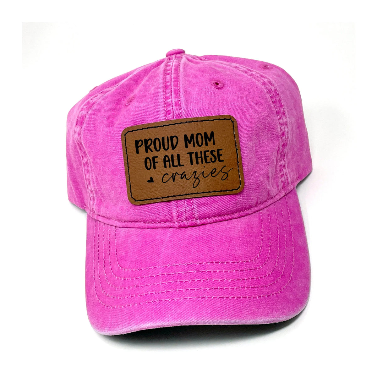 Pink washed baseball cap with brown leather “Proud Mom of all these crazies” patch