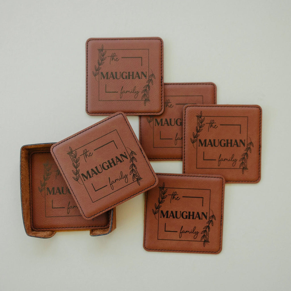 Personalized leather-look coasters in warm brown with family name and leaf wreath design