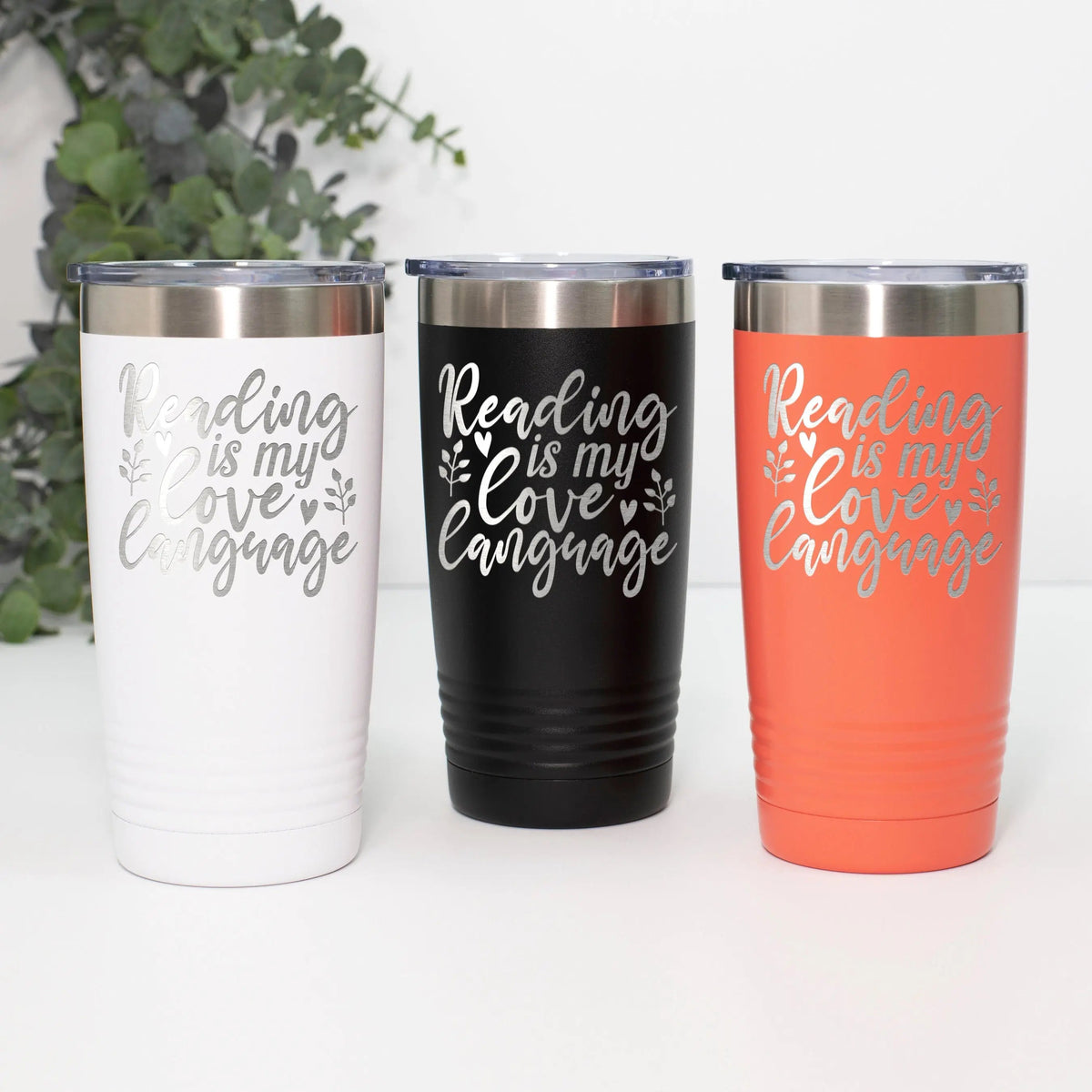 Engraved reading tumbler set with white, black, and orange cups and script message