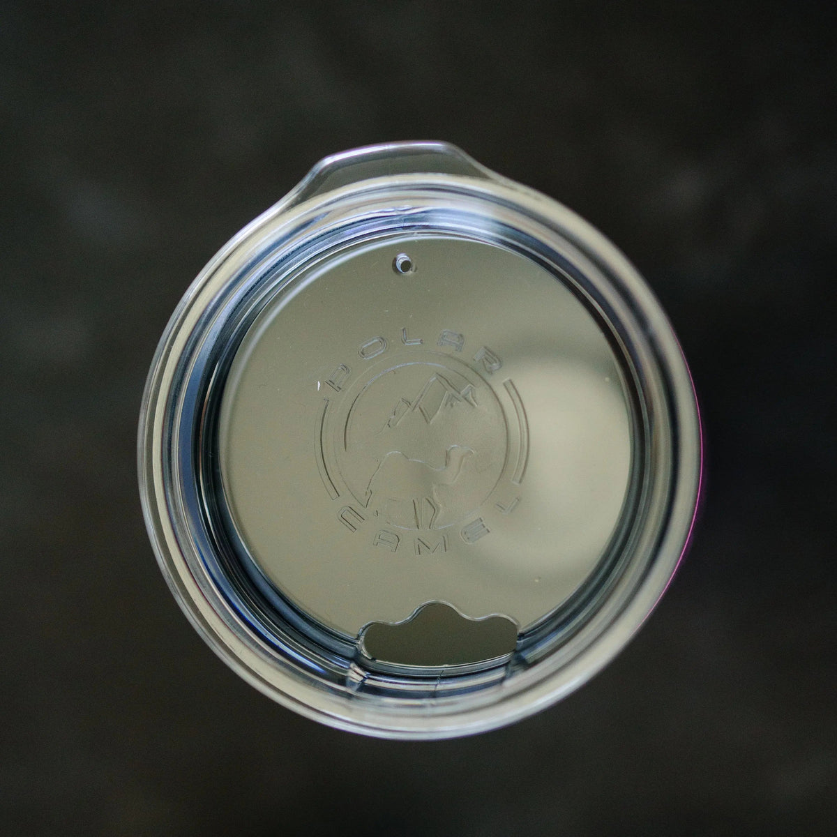 Stainless tumbler lid with straw hole and embossed logo, top view