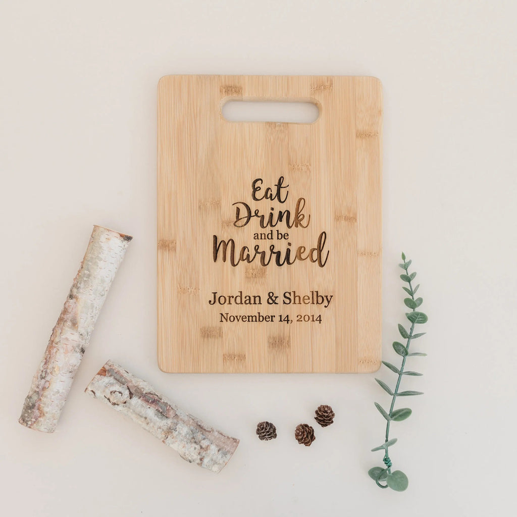 Light bamboo cutting board with handle, engraved wedding message and couple date.