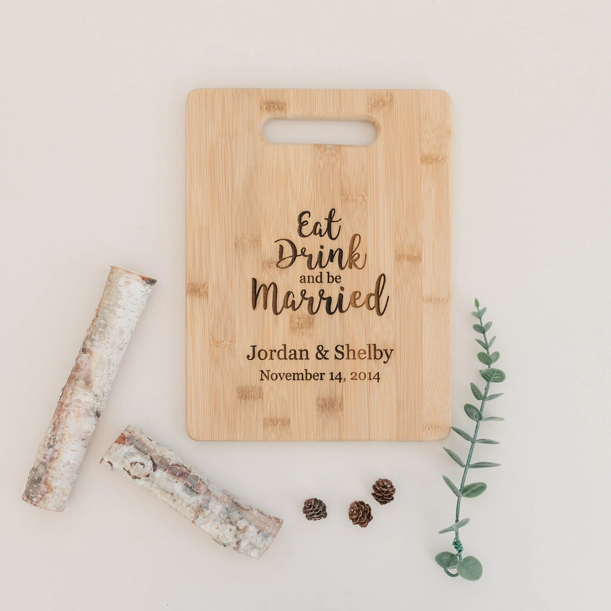 Light bamboo cutting board with handle, engraved wedding message and couple date.
