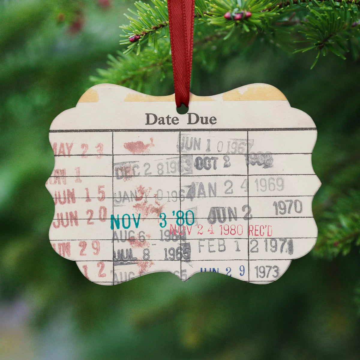 Date Due Christmas ornament with red hanging ribbon and printed date grid