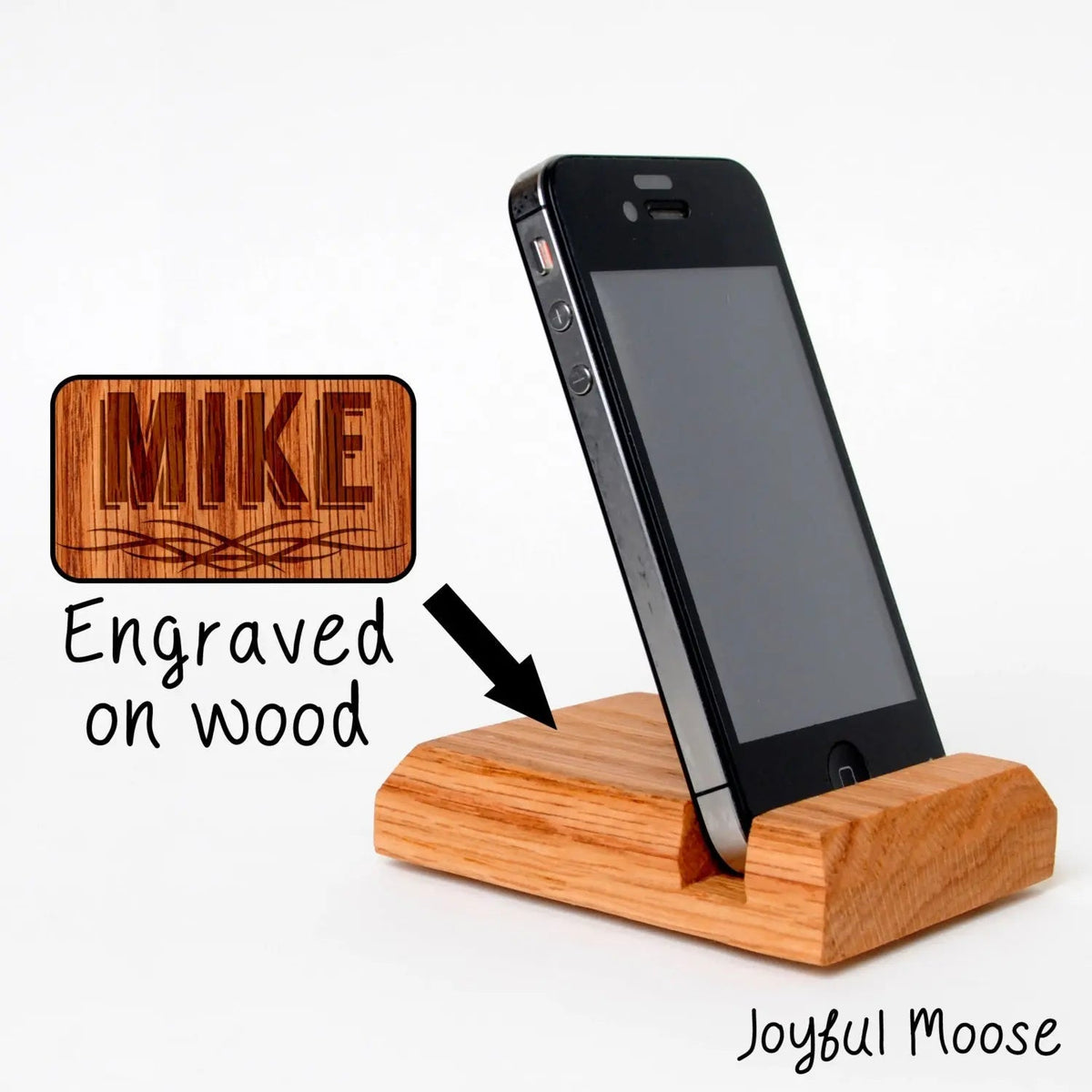 Engraved wood phone docking station with black felt slot, holding a smartphone upright
