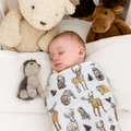 Baby swaddle blanket with cream base and woodland animal silhouettes, soft fabric