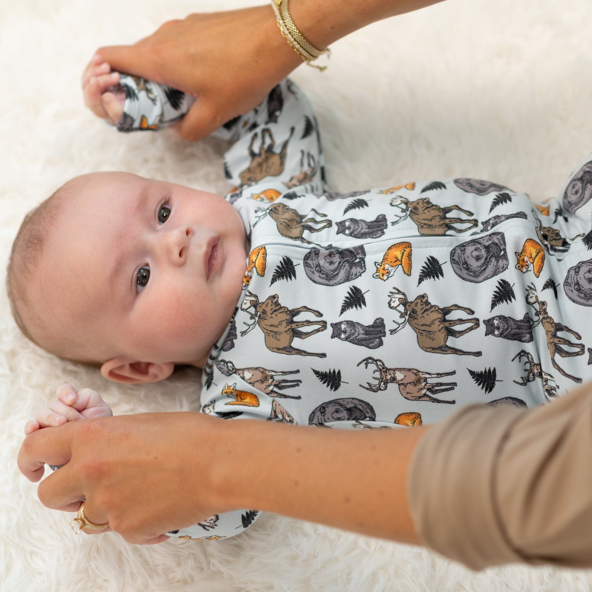 Light blue animal print zipper footie on baby, long sleeves