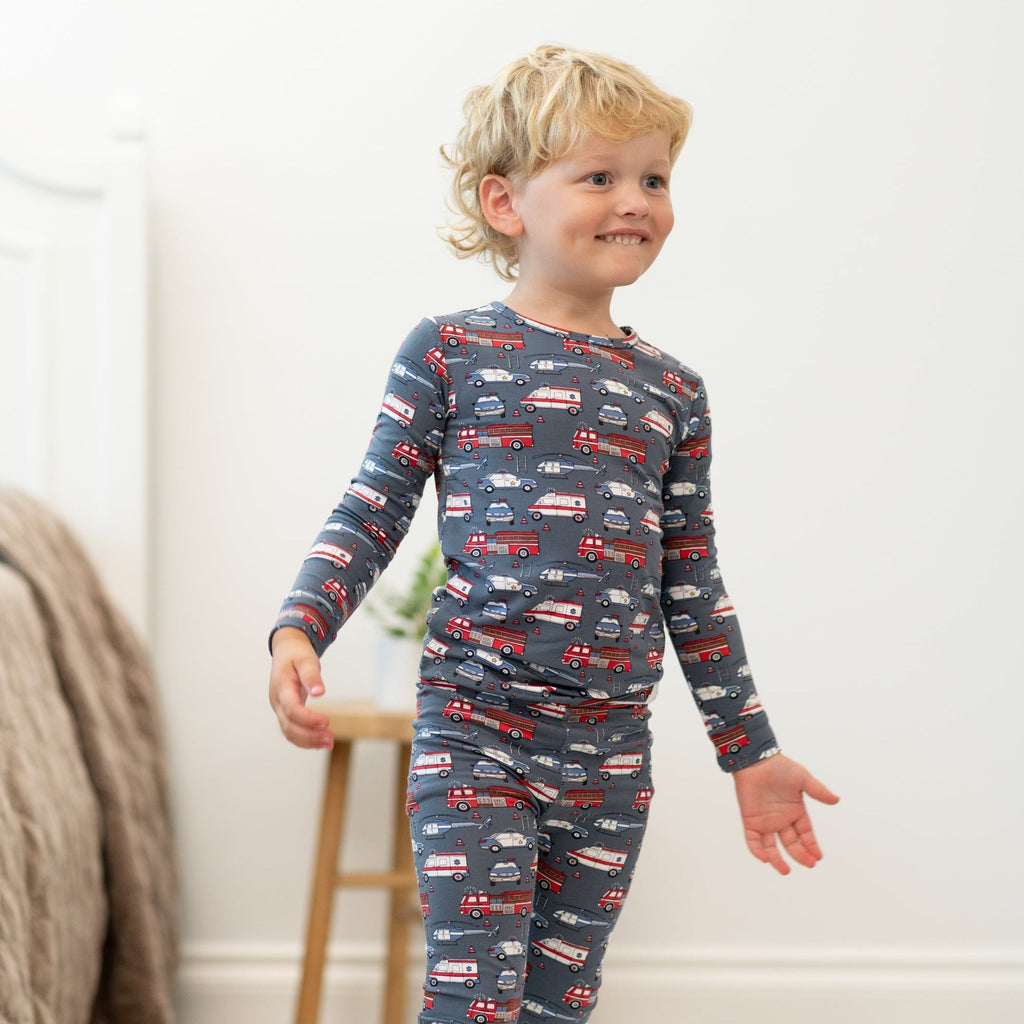 Boys long-sleeve pajamas with navy car print, smiling child standing