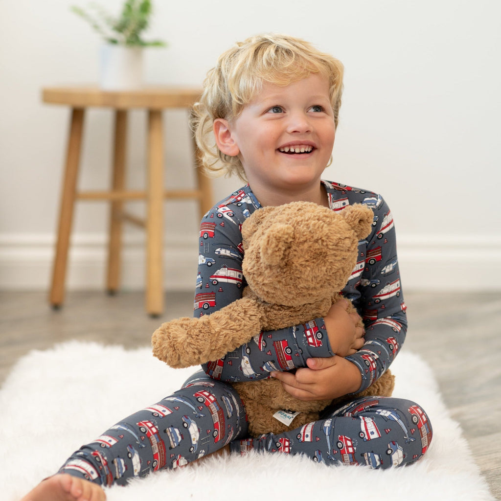 Kids pajama set, long-sleeve navy truck print, boy holding teddy bear