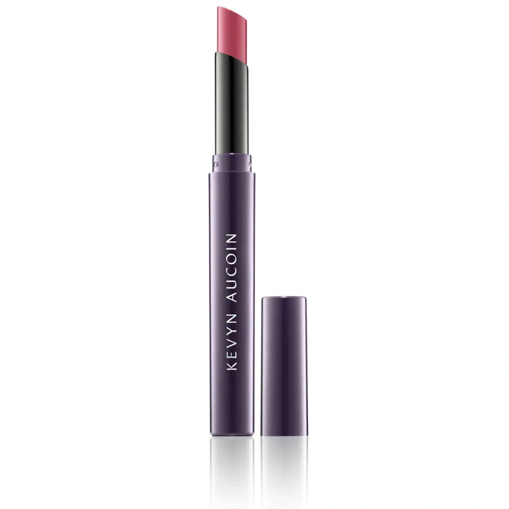 Cream lipstick in a dusty rose-pink shade, with black cap and purple tube.